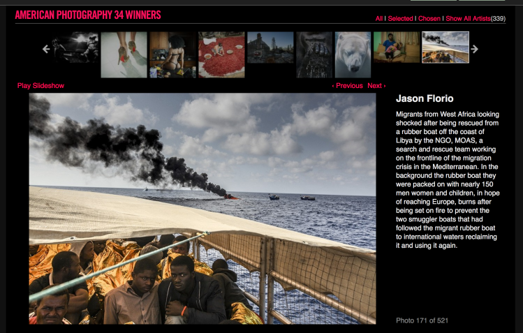 American Photography 34 Winners - image ©Jason Florio - 'Destination Europe' shell-shocked West African migrants on board rescue boat, Mediterranean, as their smugglers dinghy is set on fire in the background
